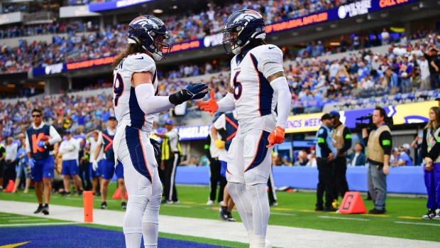 Denver Broncos safety P.J. Locke (6) celebrates with linebacker Alex Singleton (49) after stopping a scoring chance by Los Angeles Chargers tight end Gerald Everett (7) during the first half at SoFi Stadium.